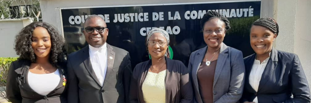 Five people standing in front of the ECOWAS Court of Justice